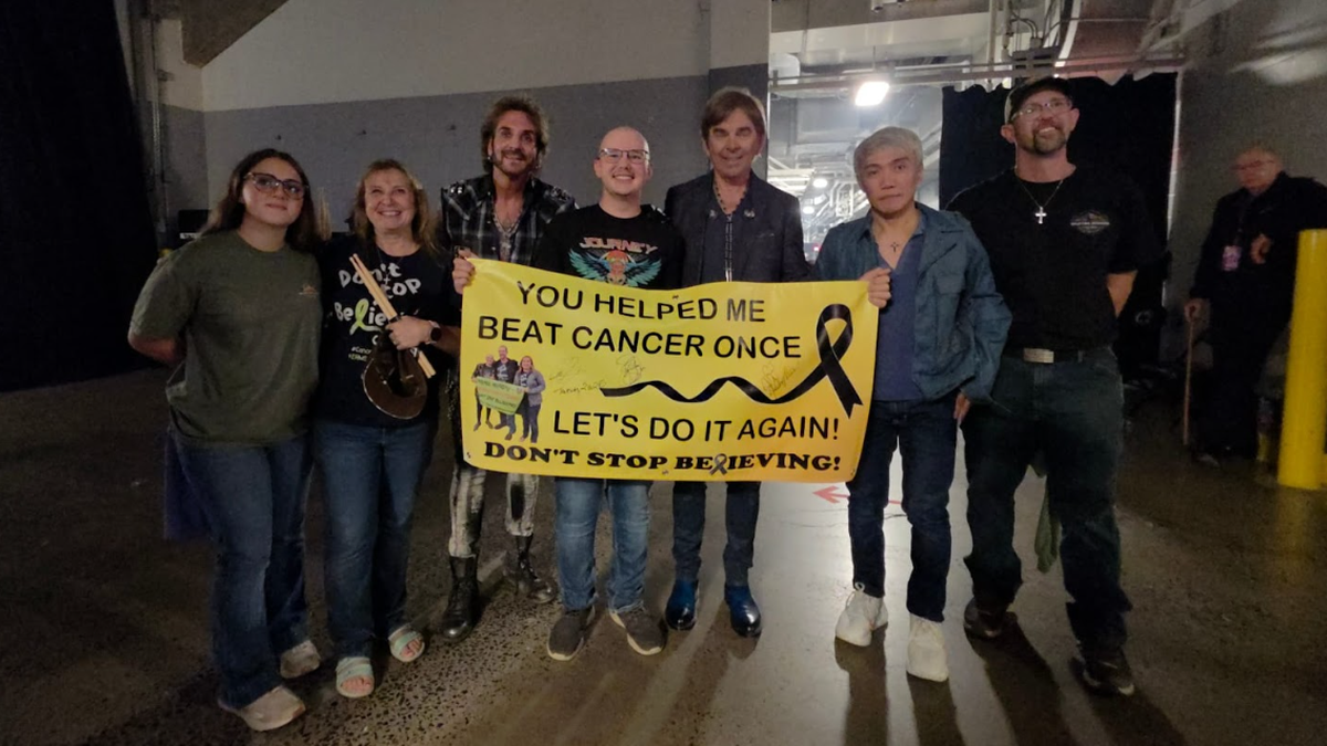 CJ Coudriet poses with family, loved ones and Journey band members before Journey’s concert Wednesday.