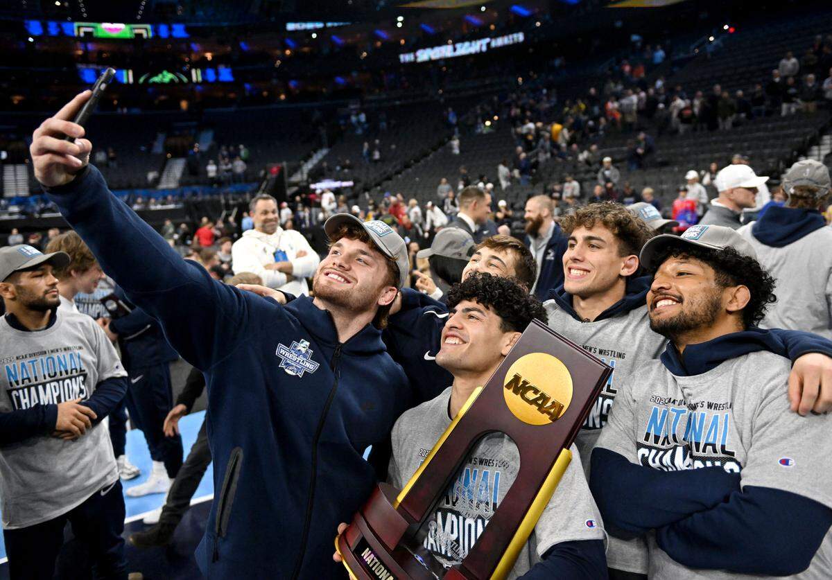 Penn State wrestler Zack Ryder talks a selfie with teammates as they celebrate winning the team title at the 2025 NCAA Wrestling Championships at the Wells Fargo Center in Philadelphia on Saturday March 22, 2025.  