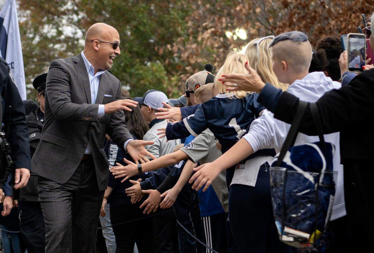Penn State football coach James Franklin high-fives fans as the team arrives at Beaver Stadium for the game against Maryland on Saturday, Nov. 12, 2022.