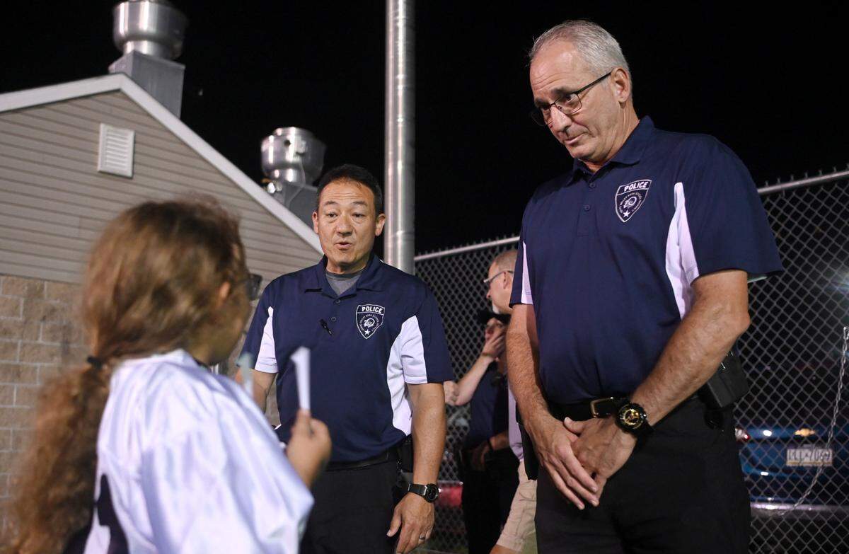 Penns Valley school district police officers Chuck Hockenberry and Kent Bernier chat with students and fans at the Penns Valley football game on Friday, Sept. 8, 2023.