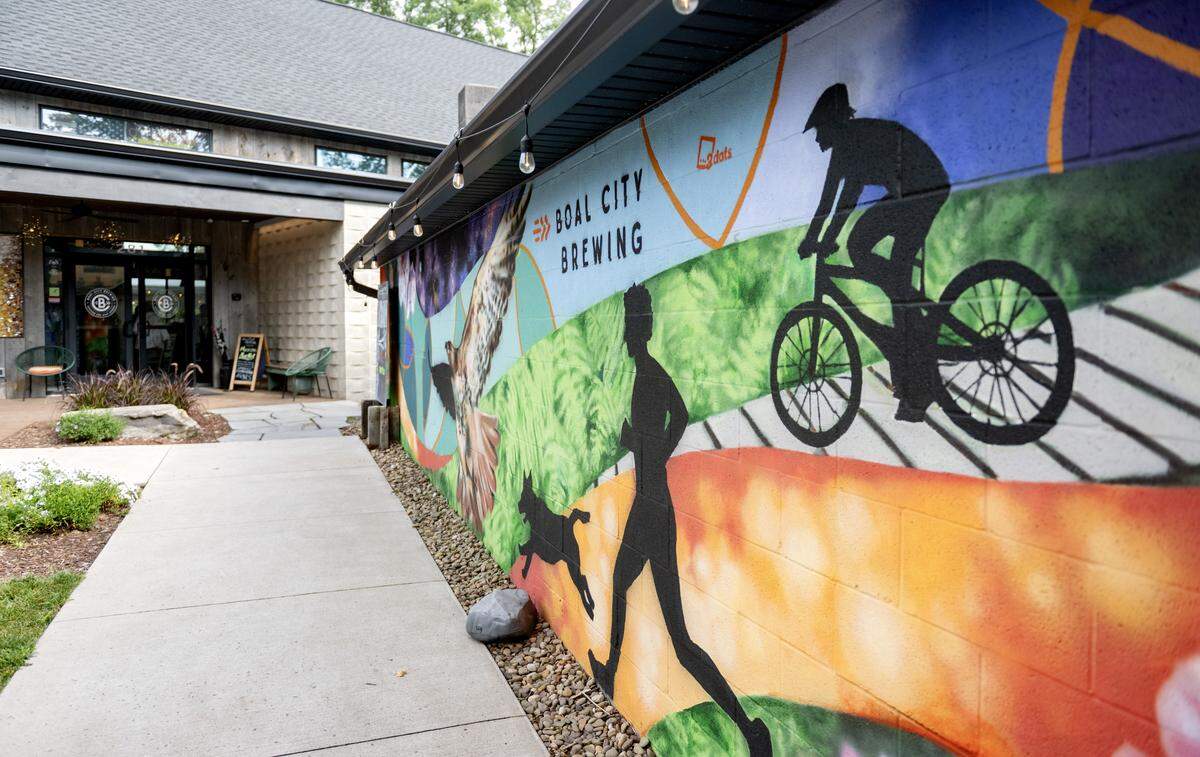 A mural painted by Magalo Guo features a biker and a runner at Boal City Brewing on Thursday, Aug. 14, 2025.  