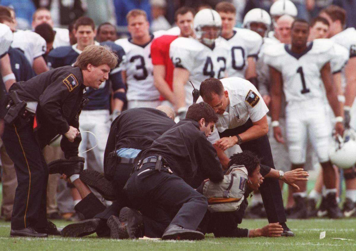 In this Centre Daily Times file photo from April 2001, police try to arrest a protester on the field of Beaver Stadium prior to the Blue-White Game.