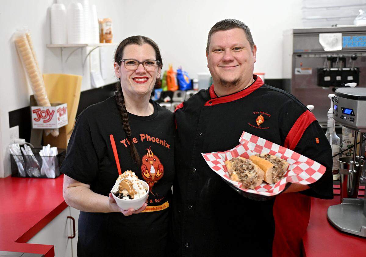 Katie Mantz-Weller and Chad Weller of The Phoenix hold a peanut butter pie sundae and a cheesesteak on Wednesday, March 25, 2026.