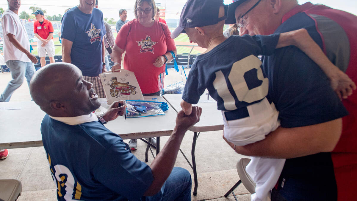 Former Penn State football star Ki-Jana Carter shakes hands with Josiah Viera as the pair laugh about not getting to coach their teams in the celebrity softball game before the New York Penn League All Star game on Tuesday, August 14, 2018.  