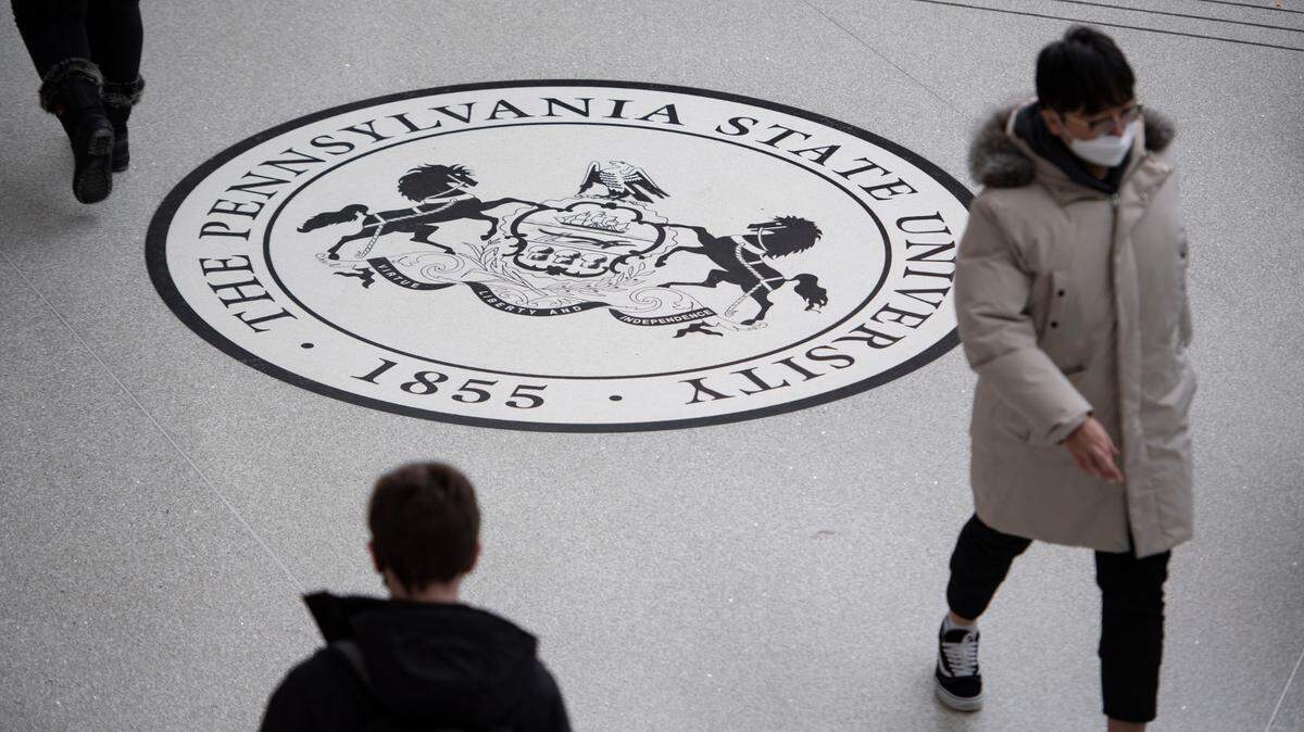 Students walk past the Penn State seal on the first day of spring classes on Monday, Jan. 10, 2022, at the HUB-Robeson Center in University Park.