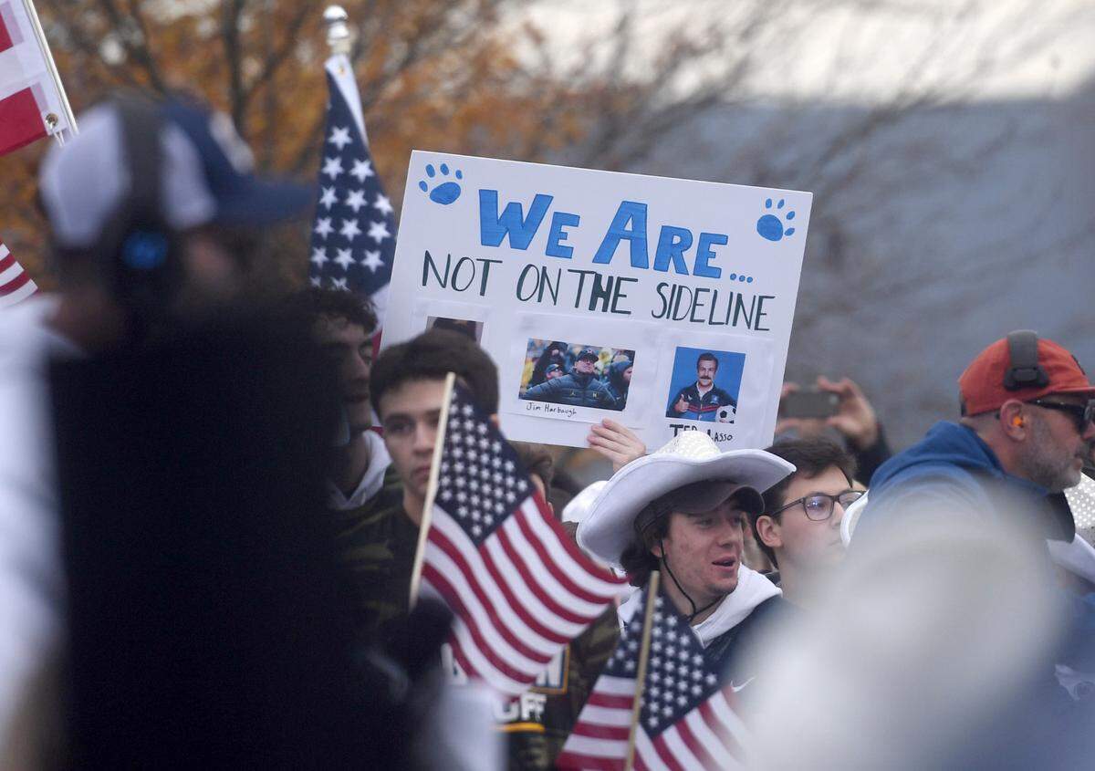 Penn State fans hold up signs at the Big Noon Kickoff about Jim Harbaugh before the game on Saturday, Nov. 11, 2023.