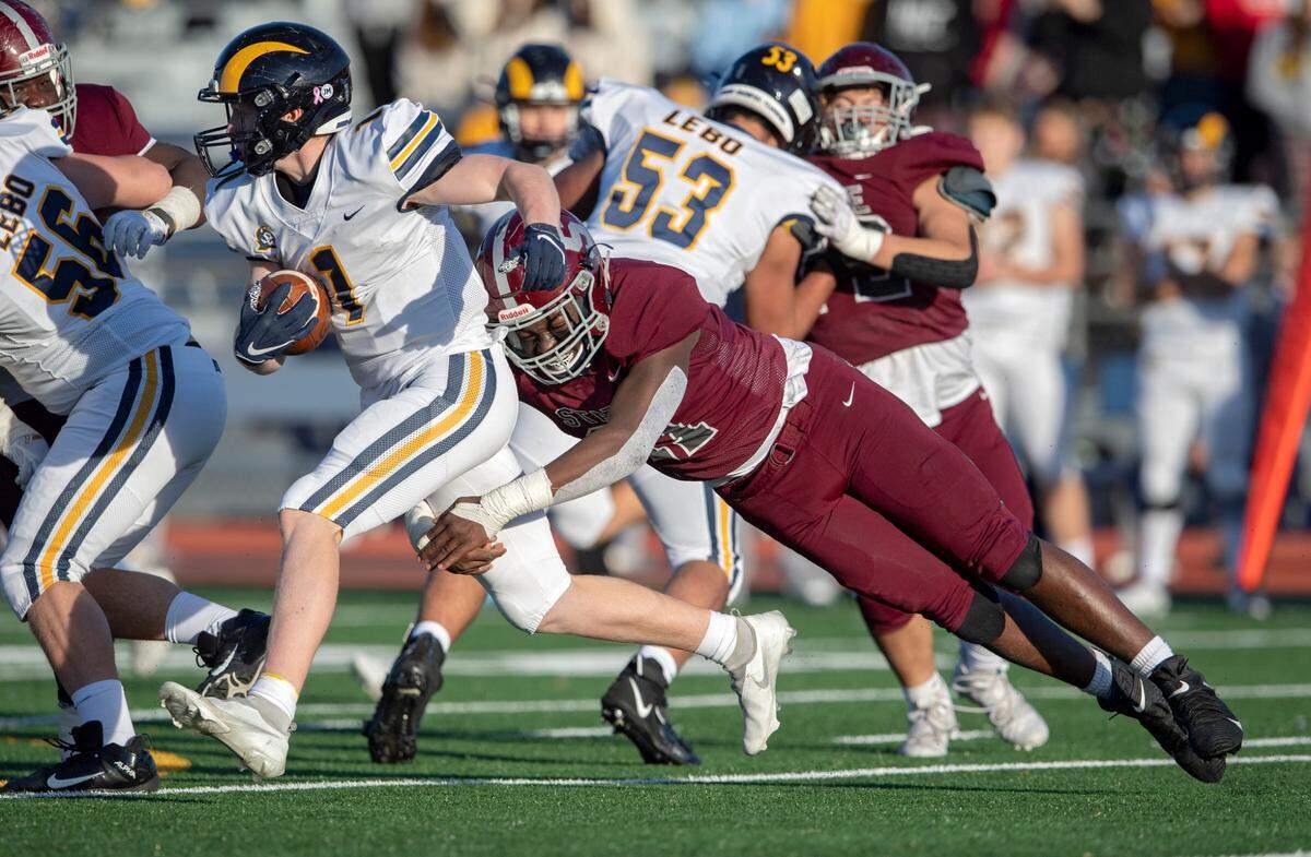 State College’s John Scott dives to stop Mt. Lebanon’s Aidan Dawson during the PIAA class 6A semifinal game on Saturday, Dec. 4, 2021 at Mansion Park. Mt. Lebanon won, 49-28.