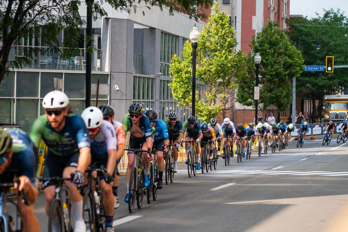 Participants in the Men’s Cat 1 and Cat 2 cycling race bike down Beaver Avenue during the State College Criterium on Saturday, July 26, 2025 in State College, Pa.