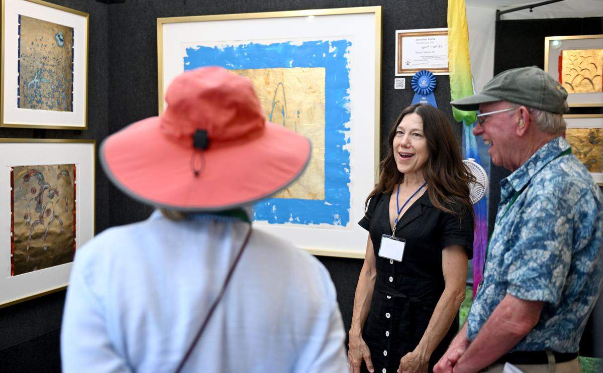 Boalsburg based artist Jennifer Kane chats with visitors to her booth at the Central Pennsylvania Festival of the Arts on Friday, July 11, 2025.