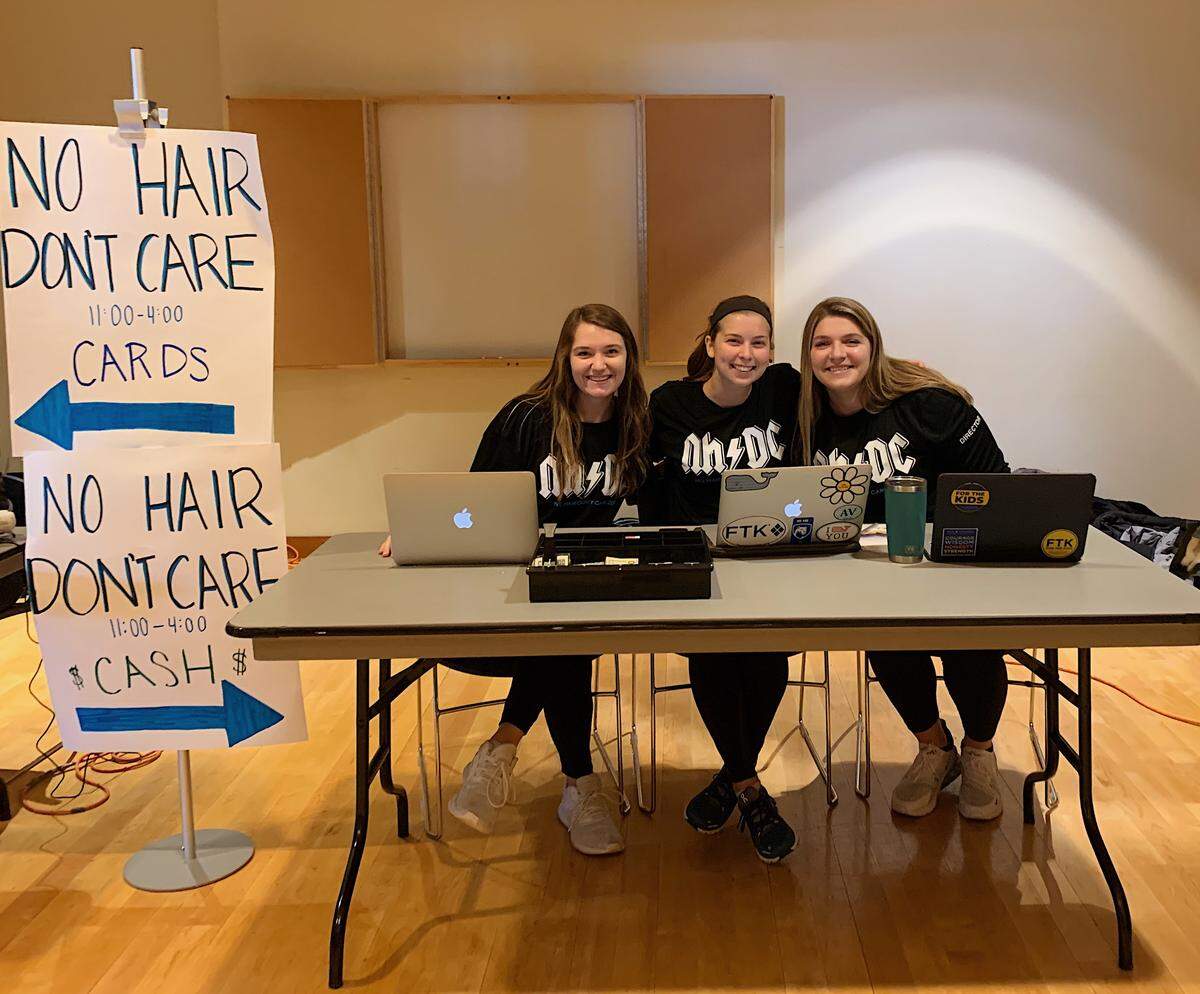 Annika Fagerstrom, Emma Farinelli, and Emily Dali pose behind the sign-in table for Thon’s “No Hair, Don’t Care” event in the HUB on Monday.