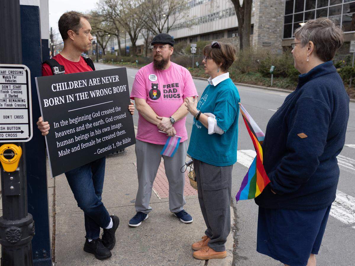 Jason Maas, left, having conversation with Matt Stumpf, second from left, and Cricket Hunter on Allen Street during the Transgender Day of Visibility event on March 31, 2025.