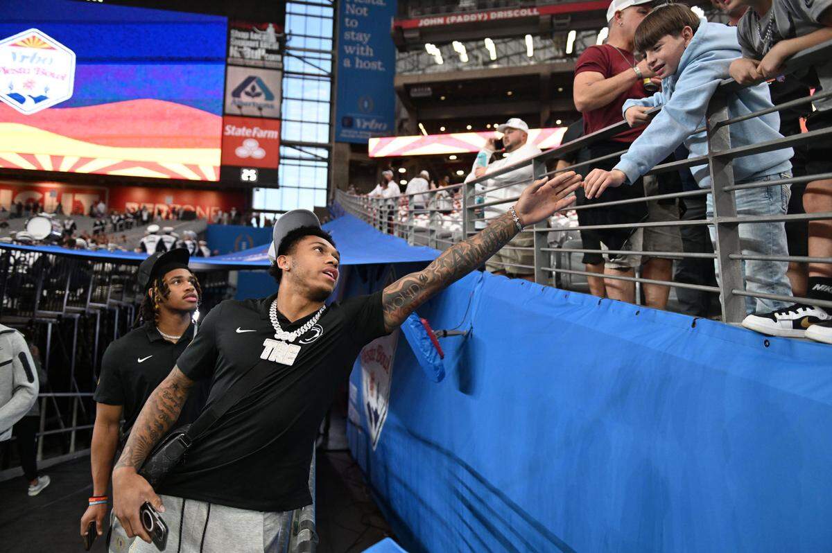 Penn State wide receiver Tre Wallace high-fives fans as he arrives at State Farm Stadium for the Fiesta Bowl on Tuesday, Dec. 31, 2024.