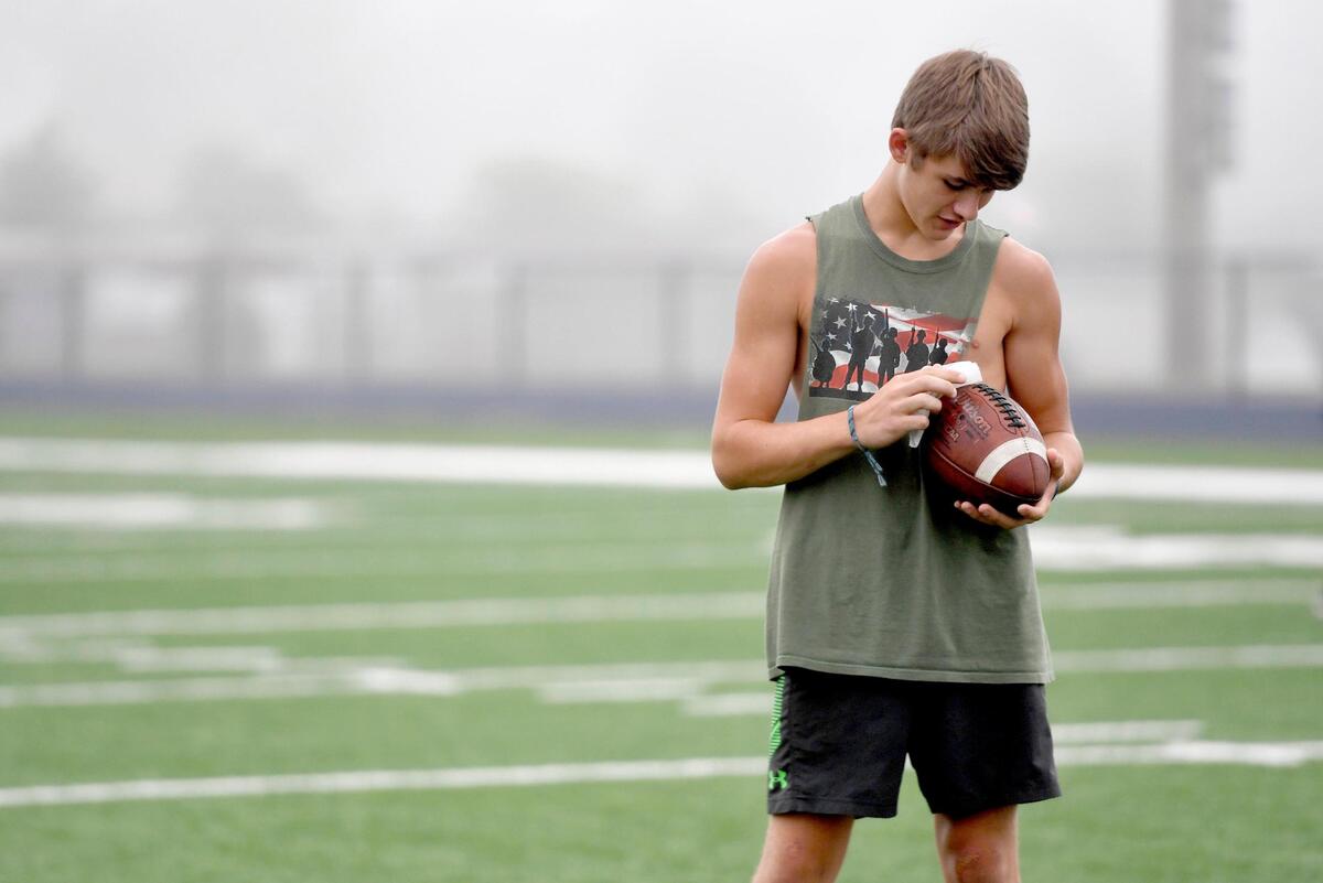 Bald Eagle Area’s Garrett Burns wipes down a football between plays during a morning summer workout on Friday, July 10, 2020.