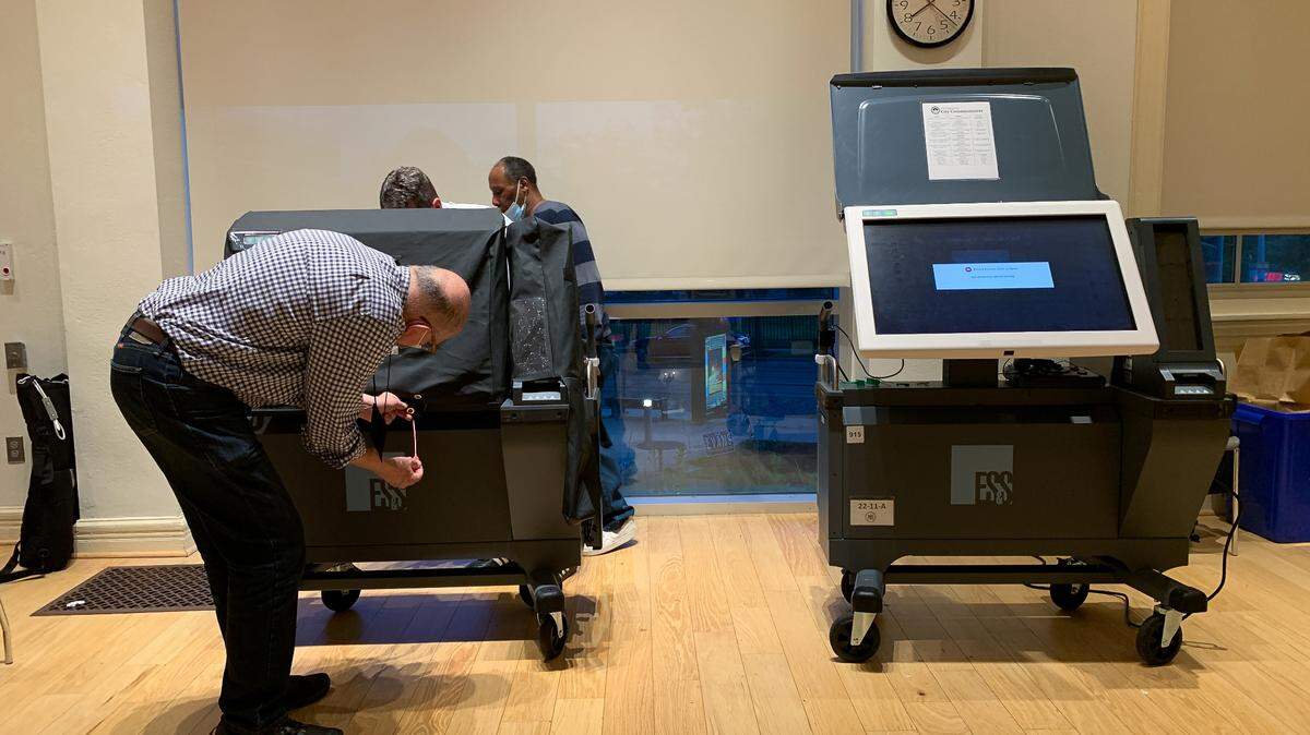 Election workers close down the voting machines in a step by step process.
