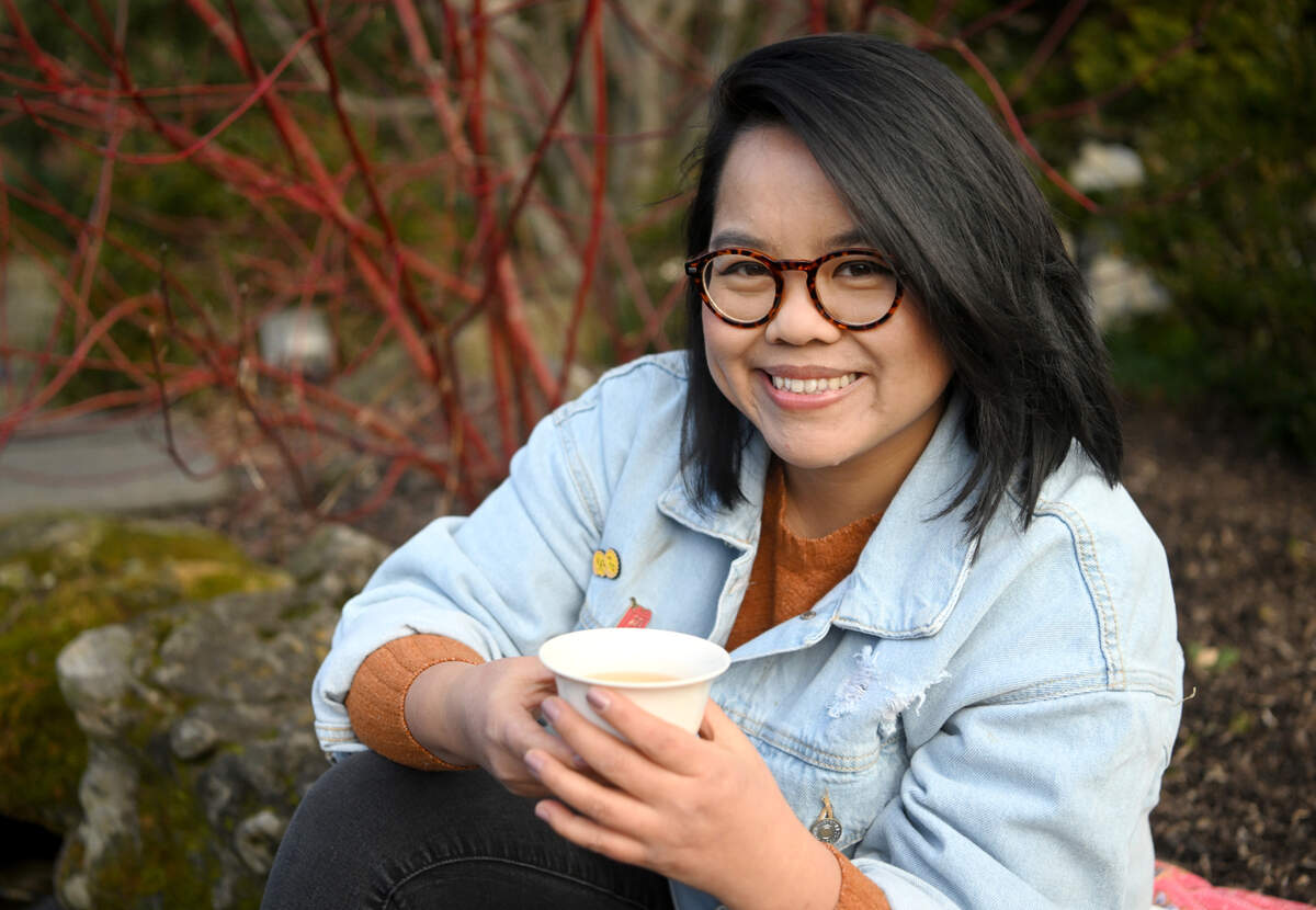 Joyce Yong of Thunder Thunder Tea enjoys a glass of jasmine while sitting next to pond at the Hintz Alumni Center on Tuesday, Jan. 31, 2023.