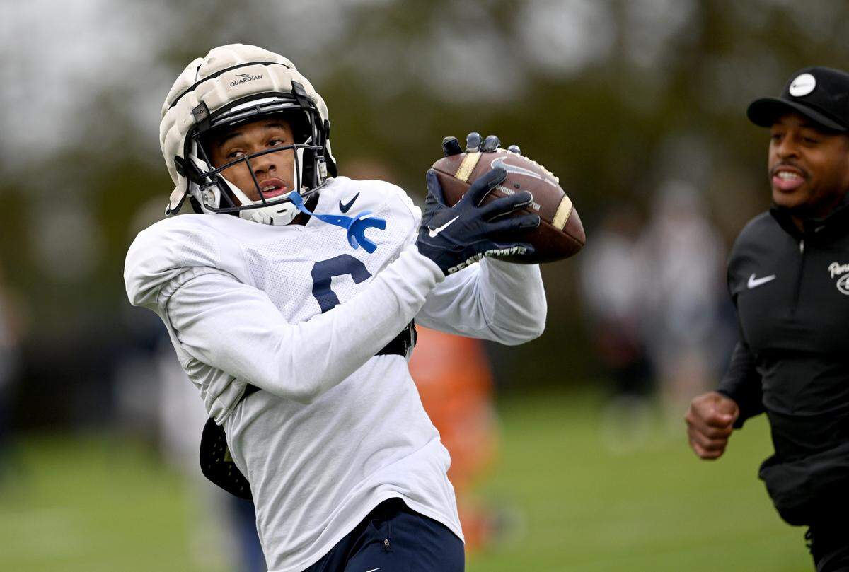 Penn State’s Harrison Wallace III makes a catch as Penn State wide receivers coach Marques Hagans follows him during practice on Wednesday, Oct. 18, 2023.