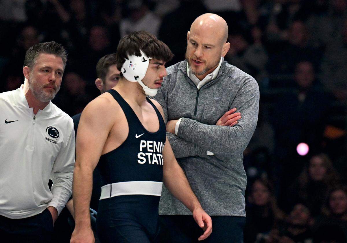 Penn State wrestling coach Cael Sanderson talks to PJ Duke as a call is reviewed during the 157 lb bout of the match on Friday, Jan. 30, 2026.