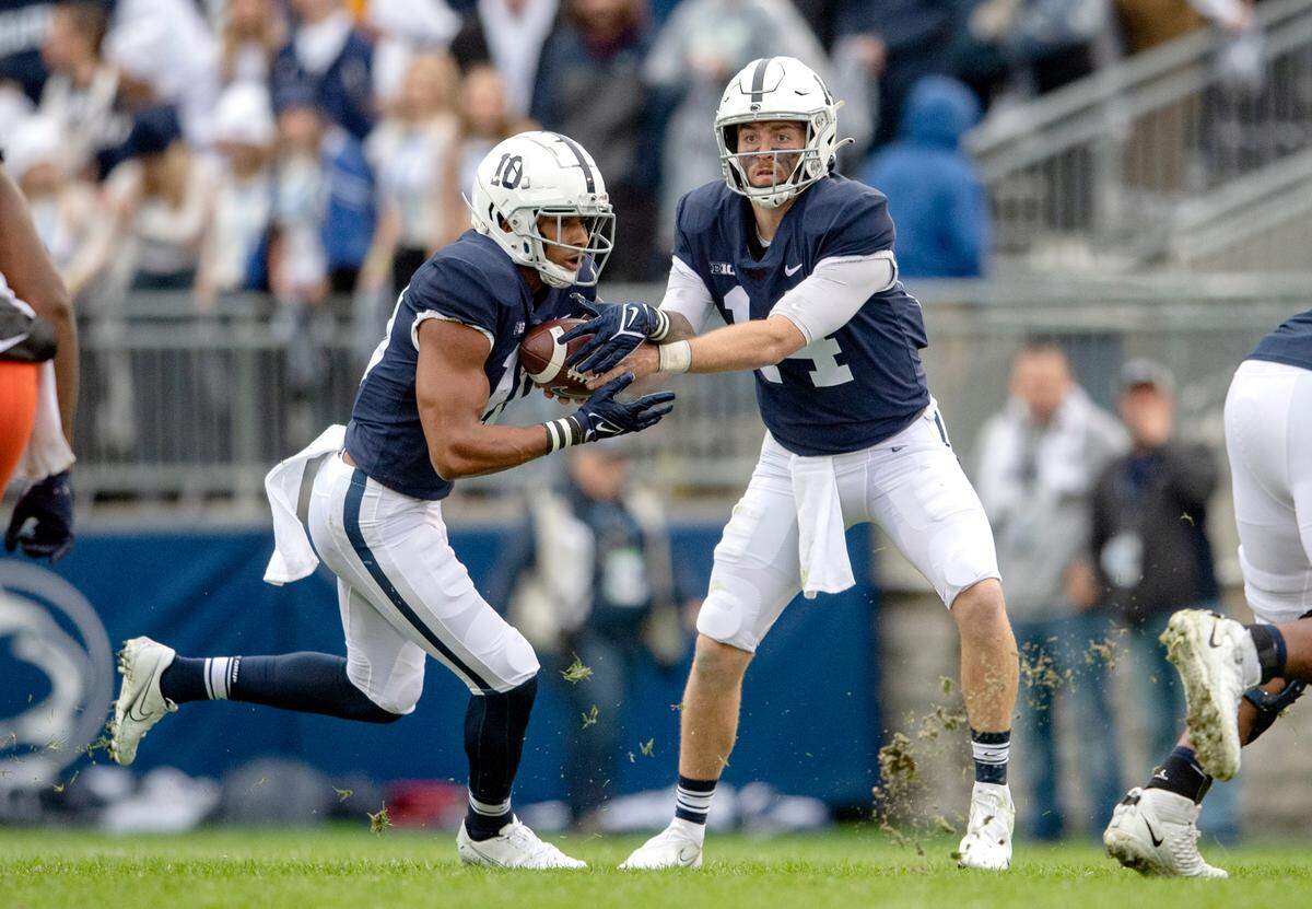 Penn State quarterback Sean Clifford hands off to running back John Lovett during the game against Illinois on Saturday, Oct. 23, 2021.