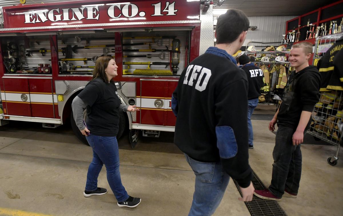 Samantha Gribble, Nick Fisher and Tyler Litz laugh together on Jan. 24 after they all checked their phones for a medical assist call that came in at during a work night at the Howard Fire Department .