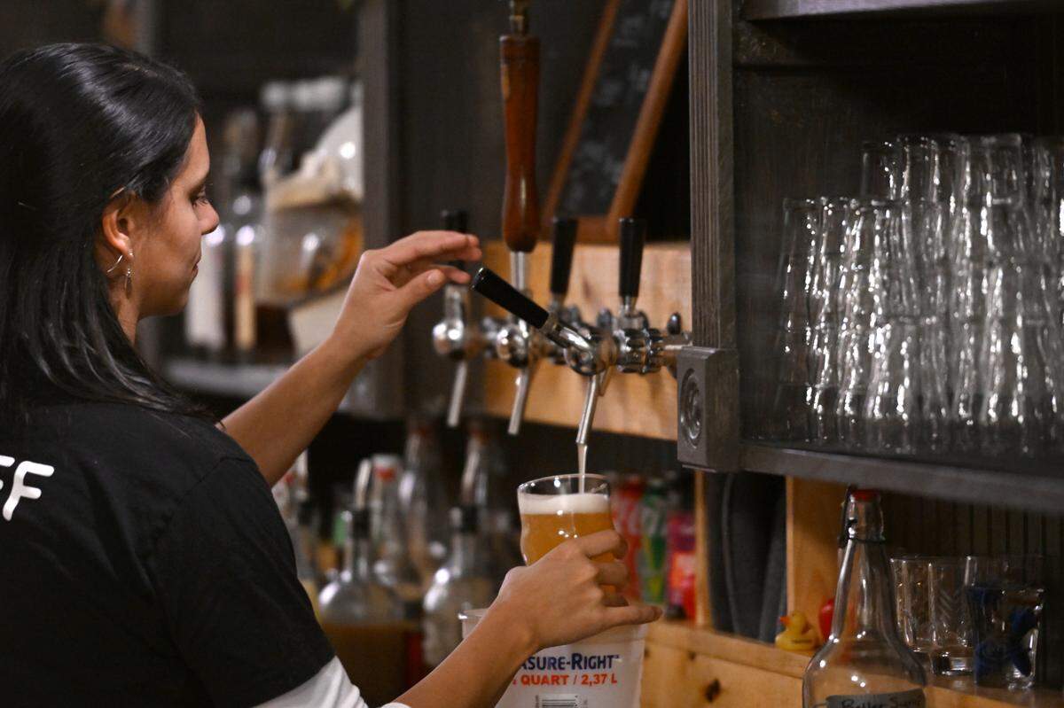 Bartender Celina Rosaro taps a beer at The Dead Canary Brewing Company in Philipsburg on Thursday, Oct. 19, 2023.