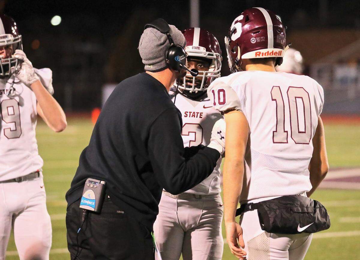 State College’s Lokey Howell (3) and quarterback Brady Dorner (10) talk with head coach Matt Lintal Friday during the Little Lions’ 48-0 win over Altoona at Mansion Park.