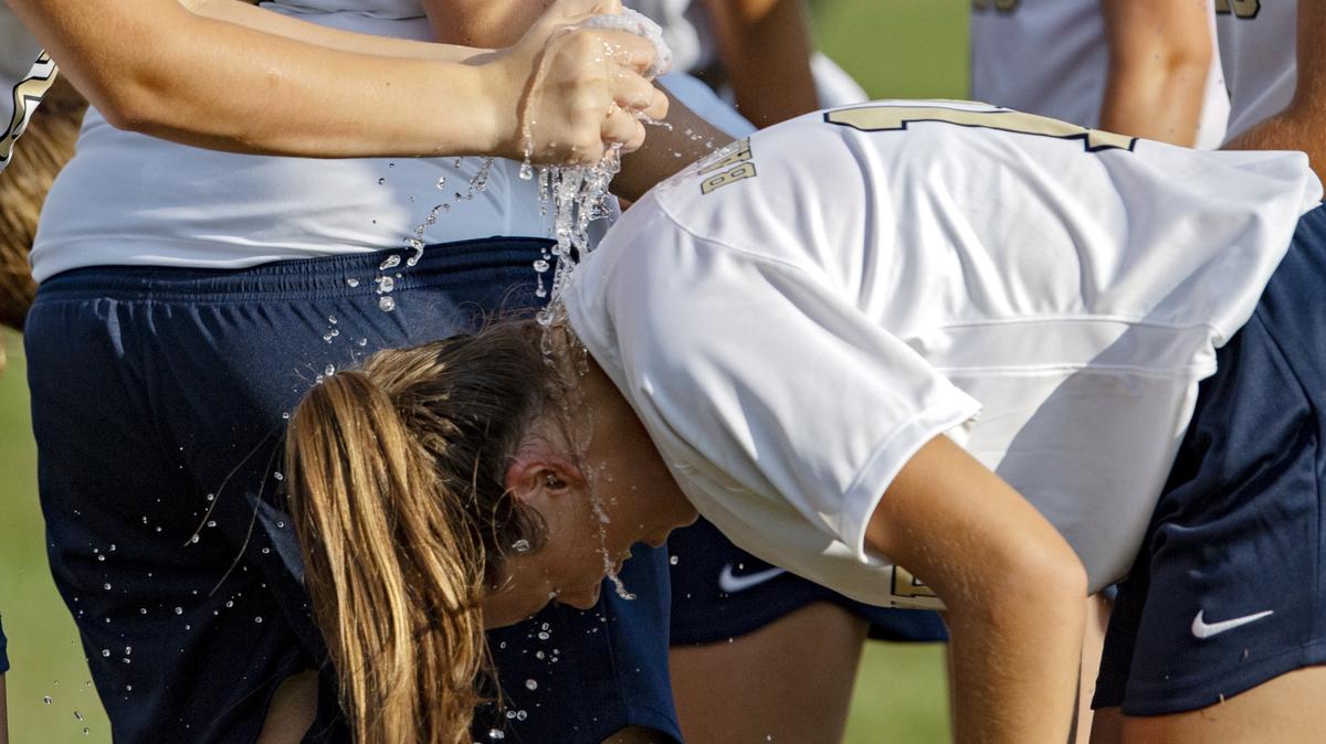 Bald Eagle Area’s Anna Cingle has cold water squeezed on her from a teammate as they take a full team water break during the game against Bellefonte on Tuesday, Sept. 4, 2018.  Officials had the players take a water break during each half, and had an extended halftime for the players to go into the air-conditioned school.