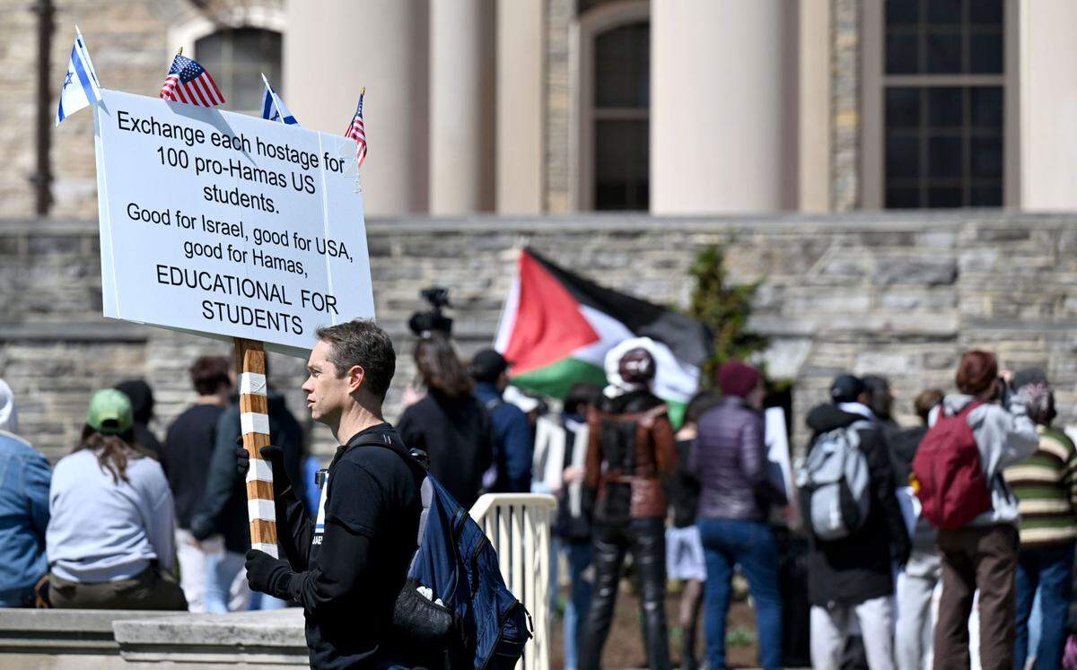 Jason Maas holds a sign as he walks around the perimeter of the Students for Justice in Palestine protest outside of Old Main on Tuesday, April 1 2025.