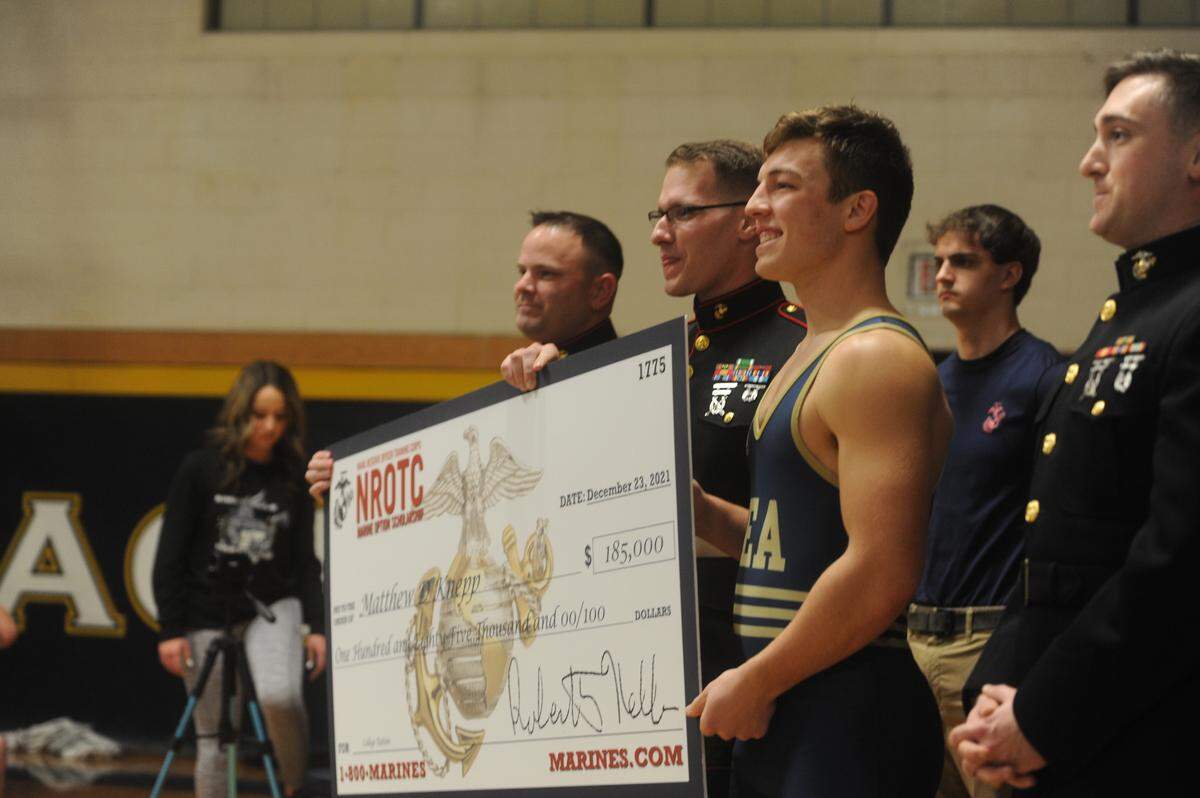 Bald Eagle Area’s Matthew Knepp receives a scholarship from the United States Marine prior to the Eagles’ 45-23 win over Brookville on Thursday. Knepp then started the dual off with a 14-10 win at 215 pounds.