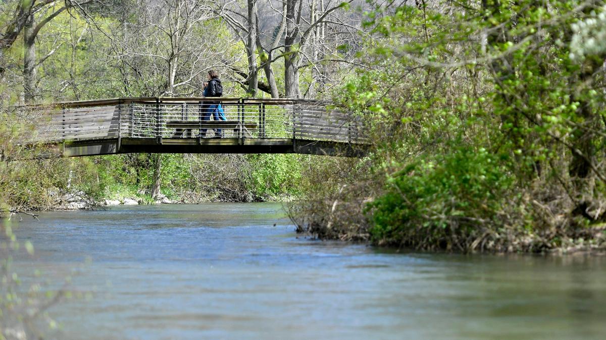 A couple crosses one of the bridges at Spring Creek Park on Monday, May 4, 2020.