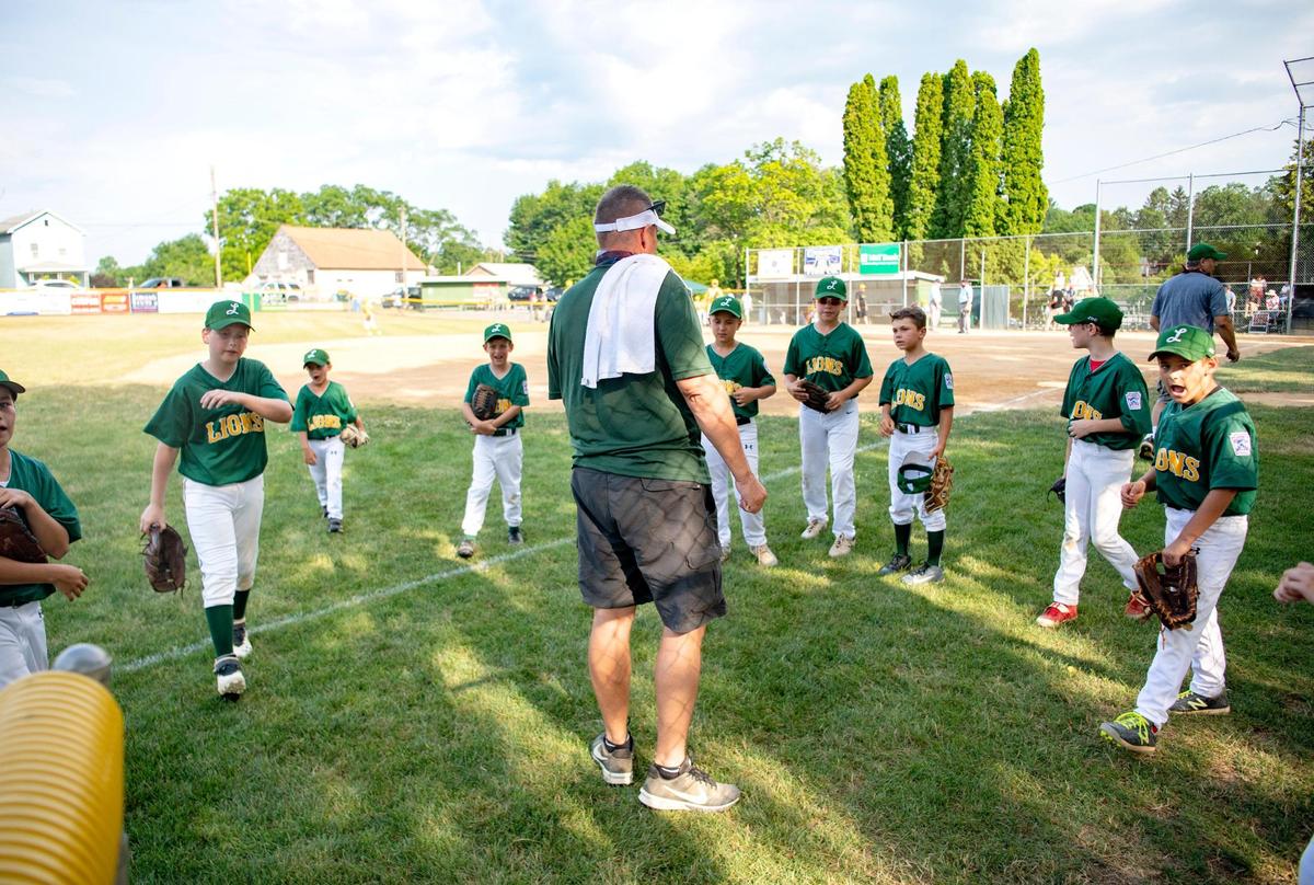 Lions coach Bill Carey has a socially distanced huddles as the players come off the field for an at bat during the game on Wednesday, July 8, 2020 at Webster Field.