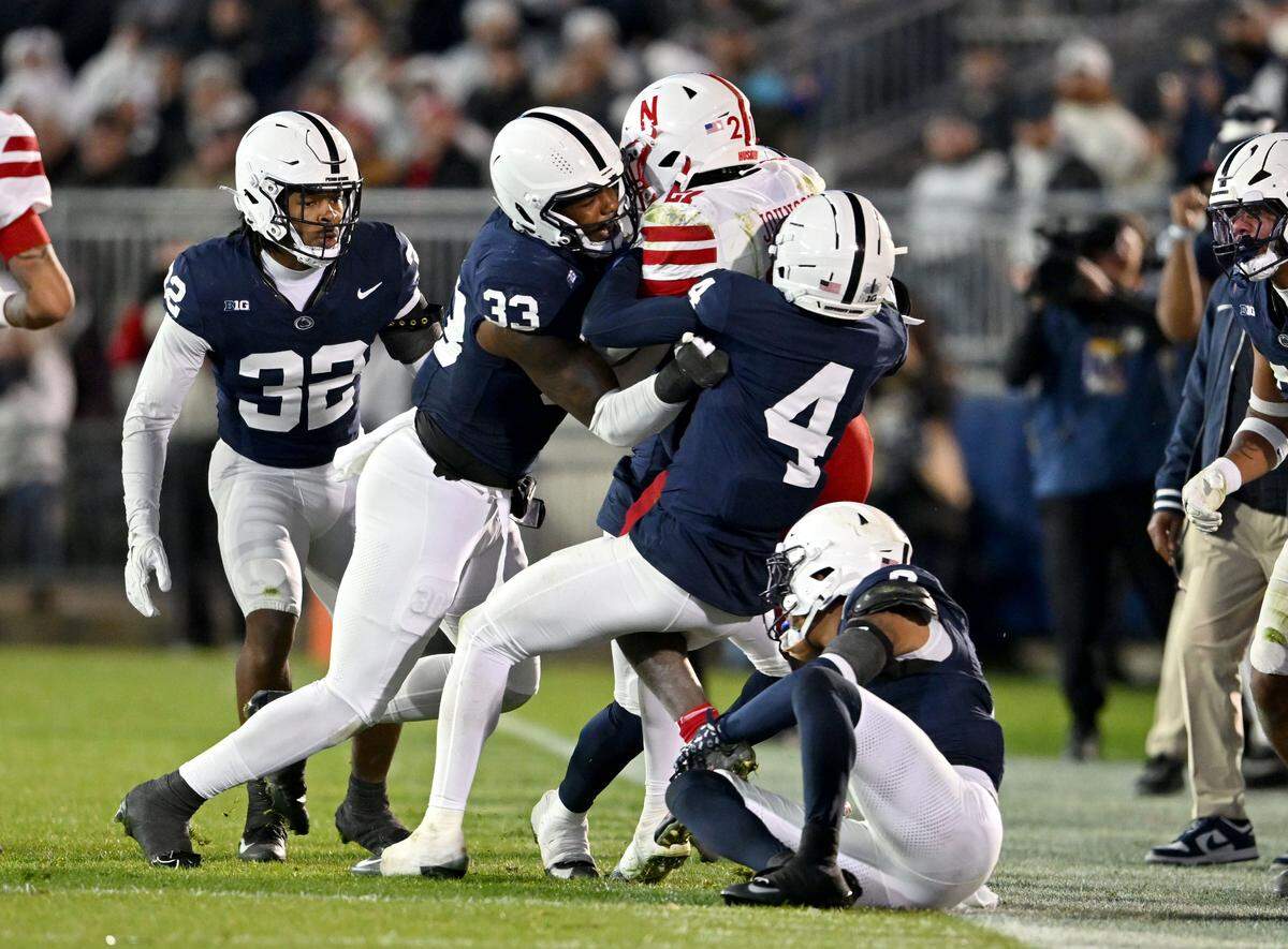 Penn State defensive end Dani Dennis-Sutton and cornerback A.J. Harris stop Nebraska running back Emmett Johnson during the game on Saturday, Nov. 22, 2025 at Beaver Stadium.
