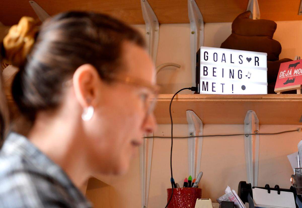 A sign above Jennifer Stahl’s desk at Centre House reads “Goals R Being Met.” Stahl struggled with housing insecurity much of her life and was able to purchase a home this year.
