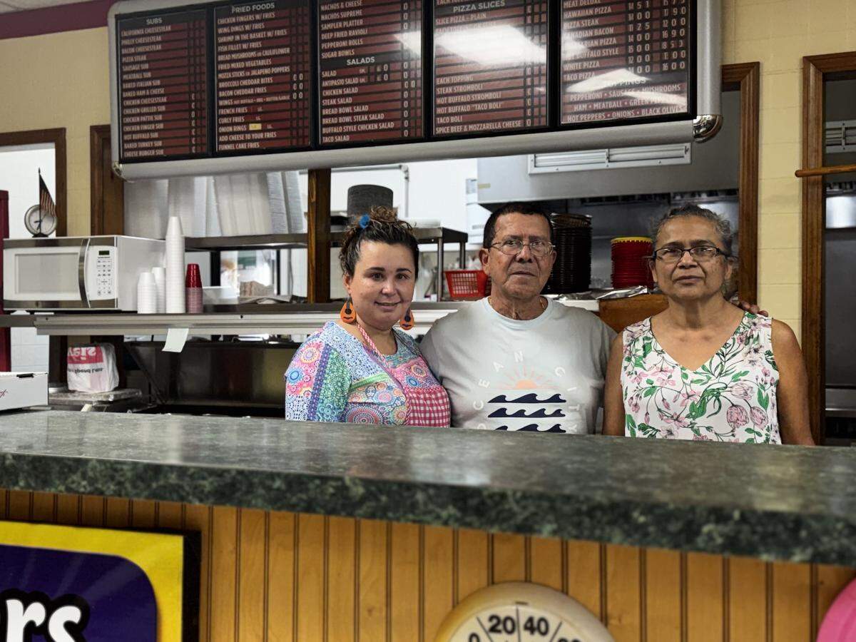 Jose’s Brothers Pizza owner Jose Estrada, center, stands with his wife, Evelyn Estrada, left, and cousin, Rosa Lopez, right, on May 27, 2026, in their Kylertown pizza shop.