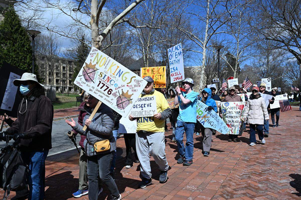 Protesters marched through the Penn State campus following a rally as part of the No Kings demonstration on Saturday.