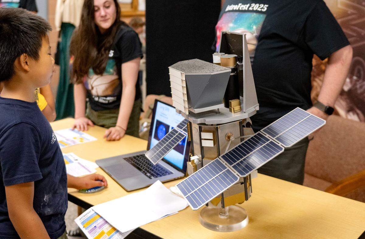 Visitors check out a model of the Swift observatory during Penn State Eberly College of Science’s AstroFest on Wednesday, July 9, 2025.