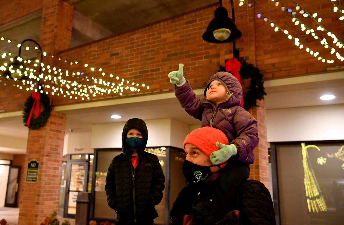 Dave Gibbons holds his daughter Della, 2, as she points at the lights on display in the Dr. Martin Luther King Jr. Plaza in downtown State College on Friday, Dec. 4, 2020.