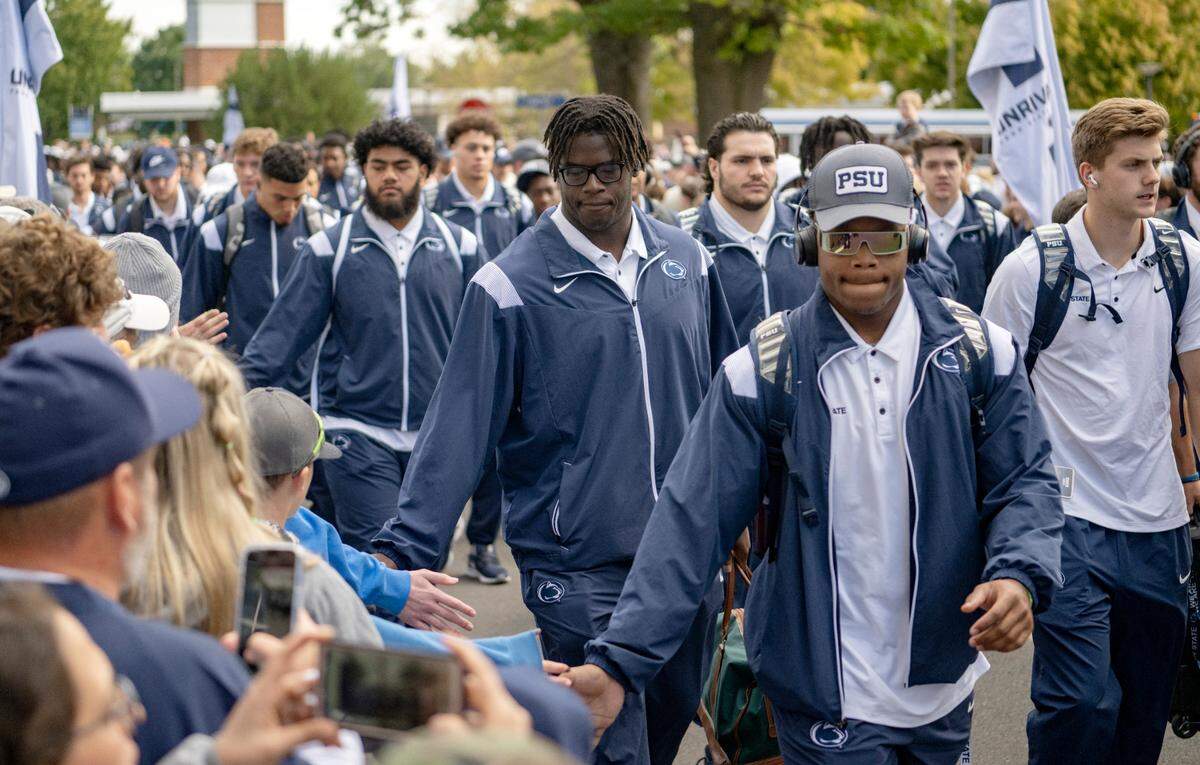 Penn State football players high five fans as they arrive at Beaver Stadium for the game on Saturday, Sept. 24, 2022.