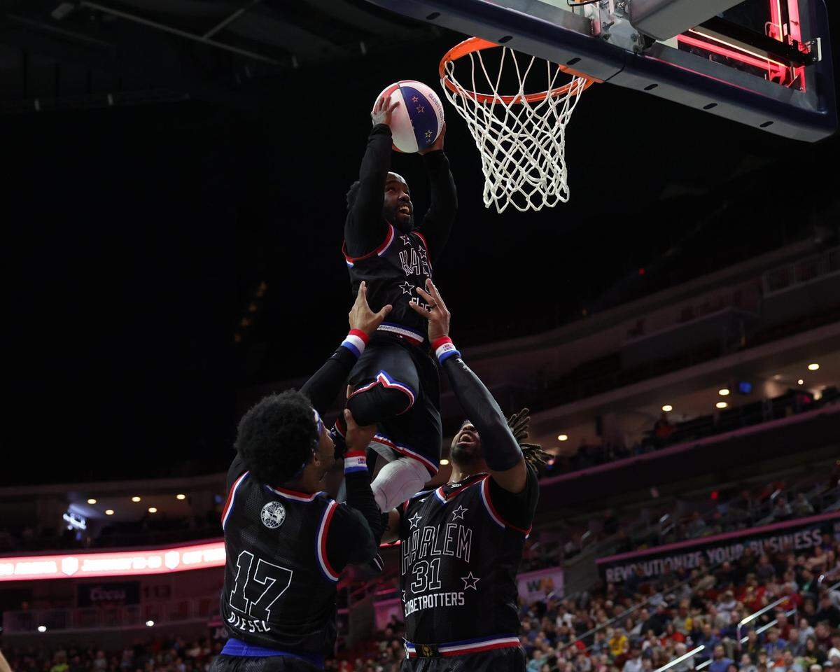 Harlem Globetrotters star Hot Shot Swanson (9) gets some help on a dunk during a game against the Washington Generals at Wells Fargo Arena in Des Moines, Iowa. Mandatory Credit: Reese Strickland-for the Register