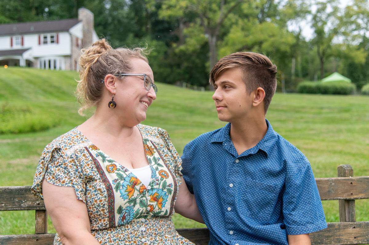 Mohnton, Pa: Dylan,13, sits with his mom, Niki Burawski, at their neighbor’s pond on Thursday, August 29, 2024. Dylan was to receive a kidney from his mom, Niki, but the operation was cancelled when Penn State Health suspended transplants. Dylan suffers from a kidney abnormality that was discovered at birth.