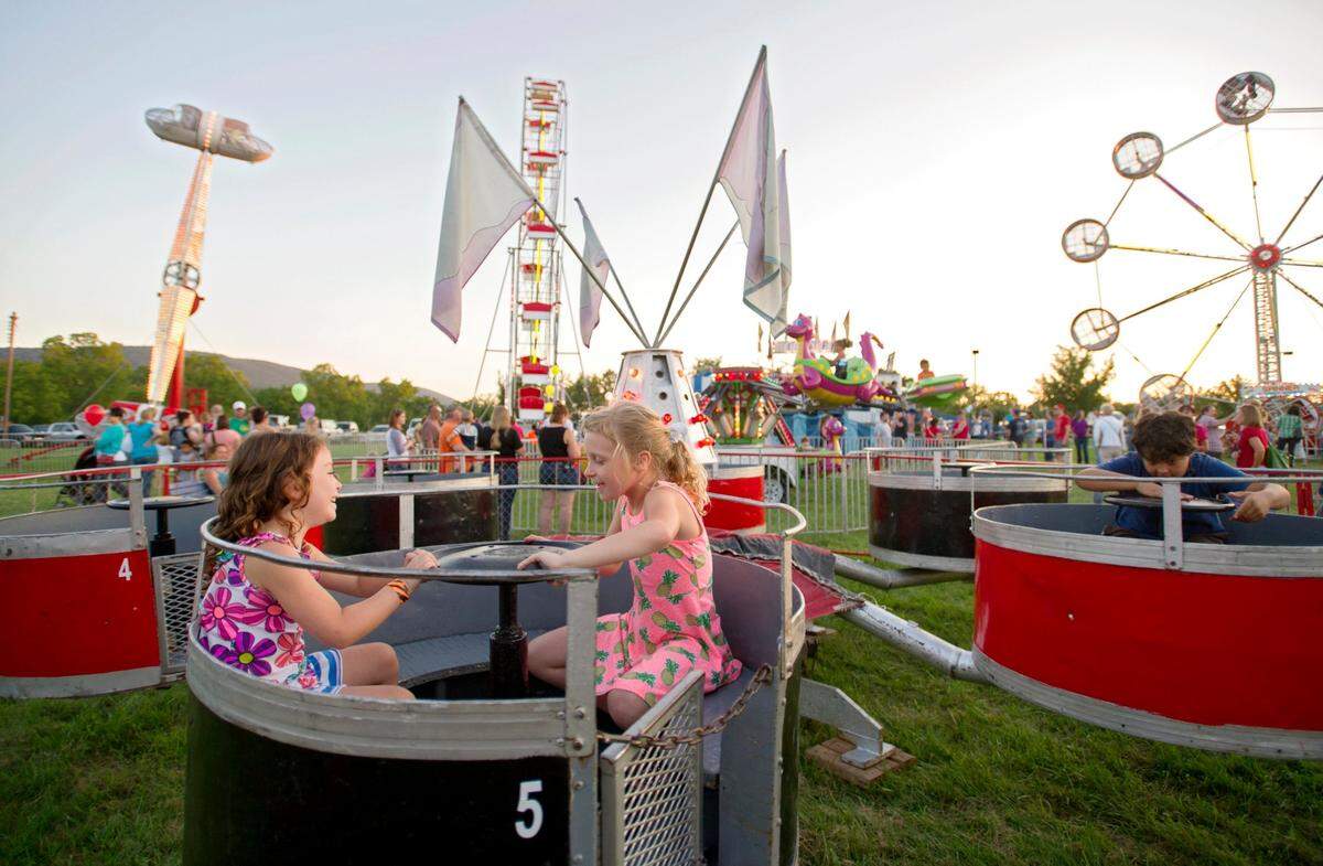 Sophia Parsons and Katelyn Stubblefield laugh as they spin on a ride at the Pleasant Gap Fire Company Carnival on July 23, 2015.