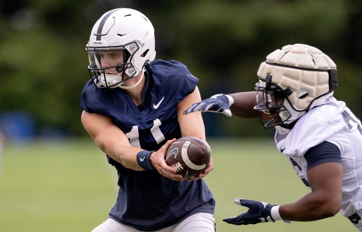 Penn State quarterback Christian Veilleux hands the ball off during the first day of practice on Monday, Aug. 1, 2022.