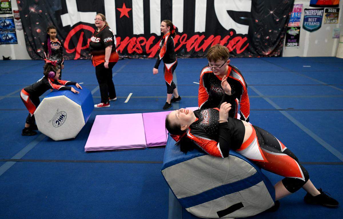 Slade Thompson helps Annalea Barger work on some back tumbling during the Fame Angels practice on Tuesday, March 12, 2024.