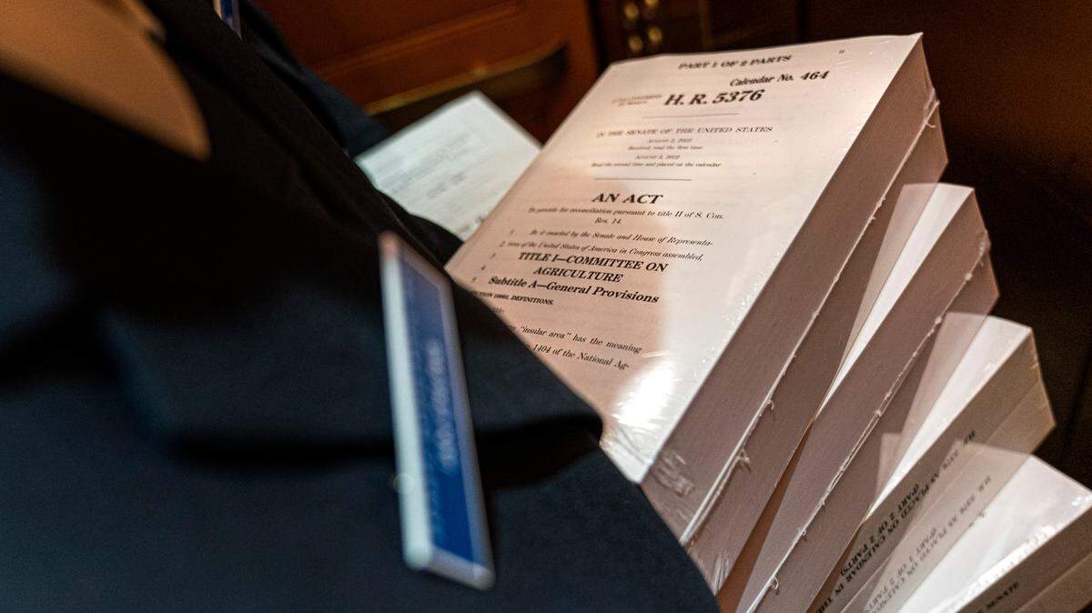 A page holds copies of the Inflation Reduction Act while riding an elevator inside the Capitol, Wednesday, Sept. 7, 2022, in Washington.