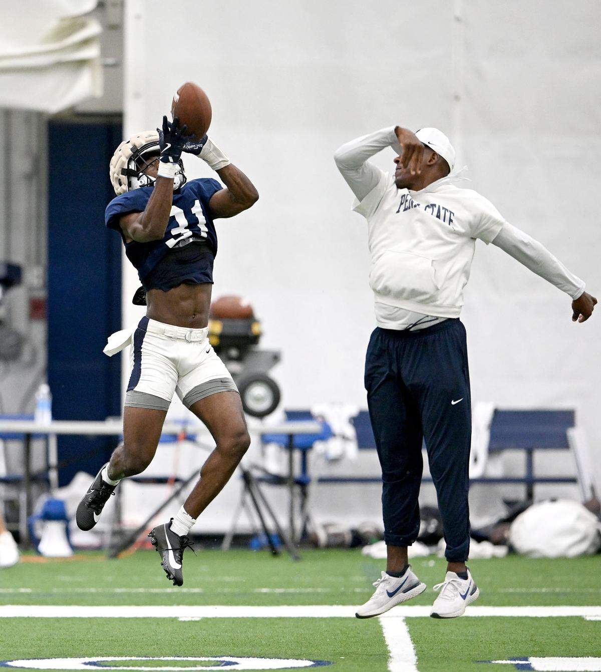 Penn State Kolin Dinkins makes a catch around safeties coach Anthony Poindexter during a drill at practice on Saturday, Aug. 3, 2024.