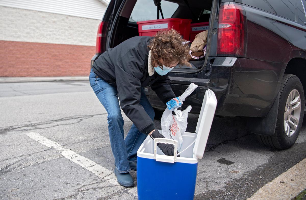 Lisa Hahn gathers a lunch and milk through the YMCA lunch program on Thursday, April 16, 2020 outside of the Columbia Fire Company in Osceola.
