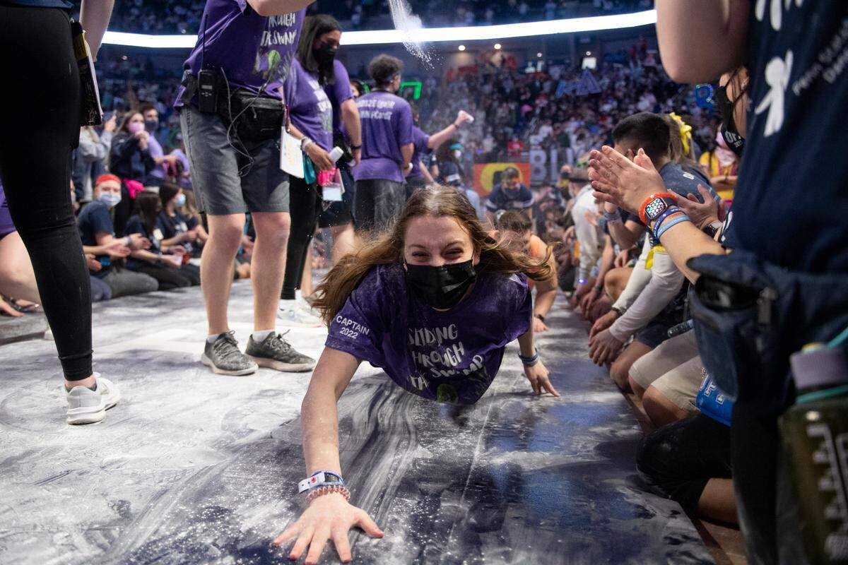 A Thon volunteer slides through baby powder during the “slides of strength” Saturday at the Penn State IFC/Panhellenic Dance Marathon.