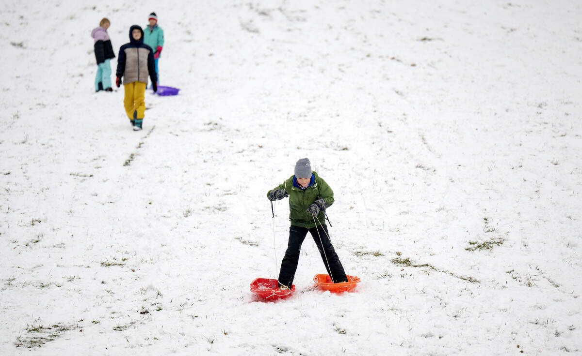 Friends watch as Greyson Pontzer uses sleds like skies at Slab Cabin Park on Tuesday, Dec. 2, 2025.