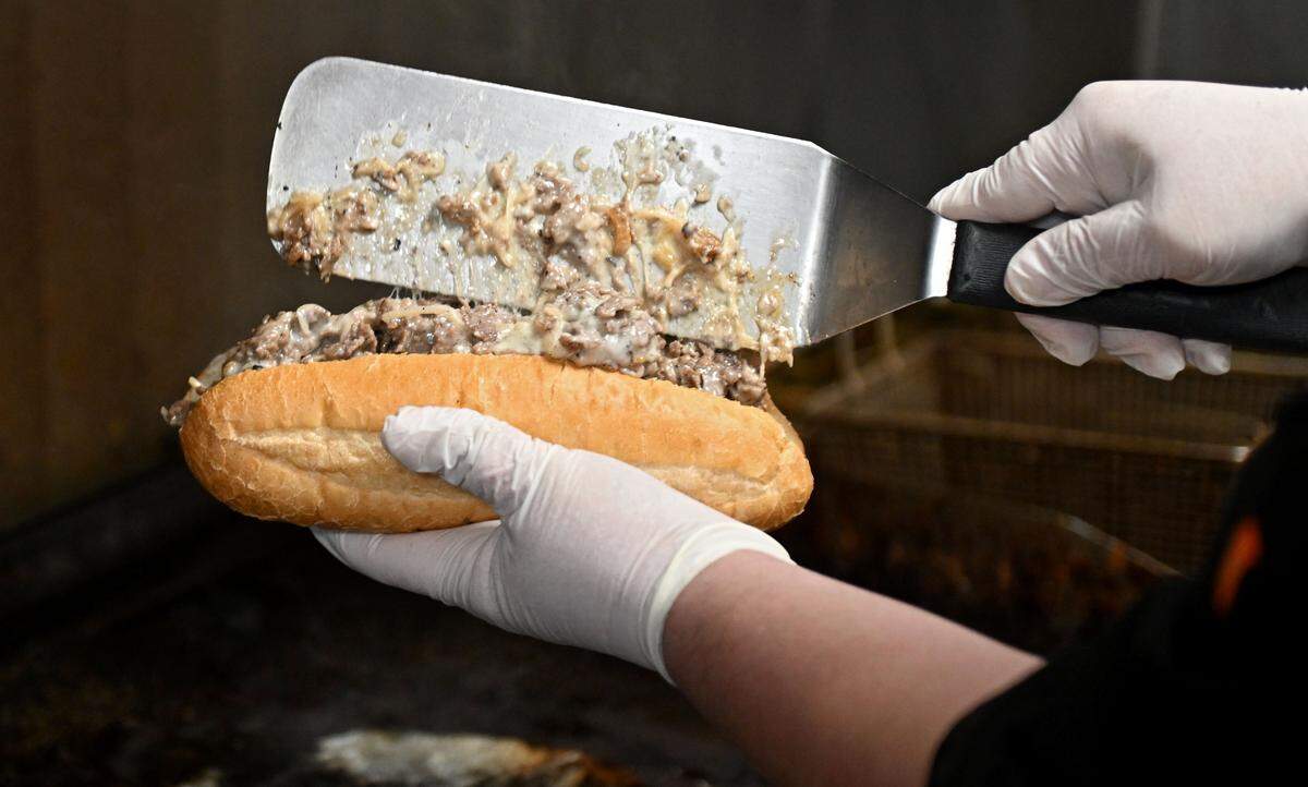 Chad Weller scoops a cheesesteak into the roll at The Phoenix on Wednesday, March 25, 2026. 