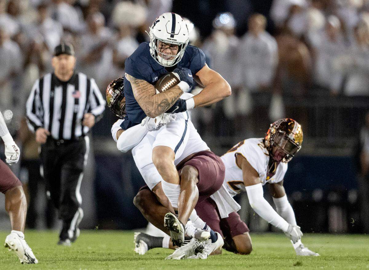 A Minnesota defender tries to pull down Penn State tight end Theo Johnson after he made a catch during the game on Saturday, Oct. 22, 2022.