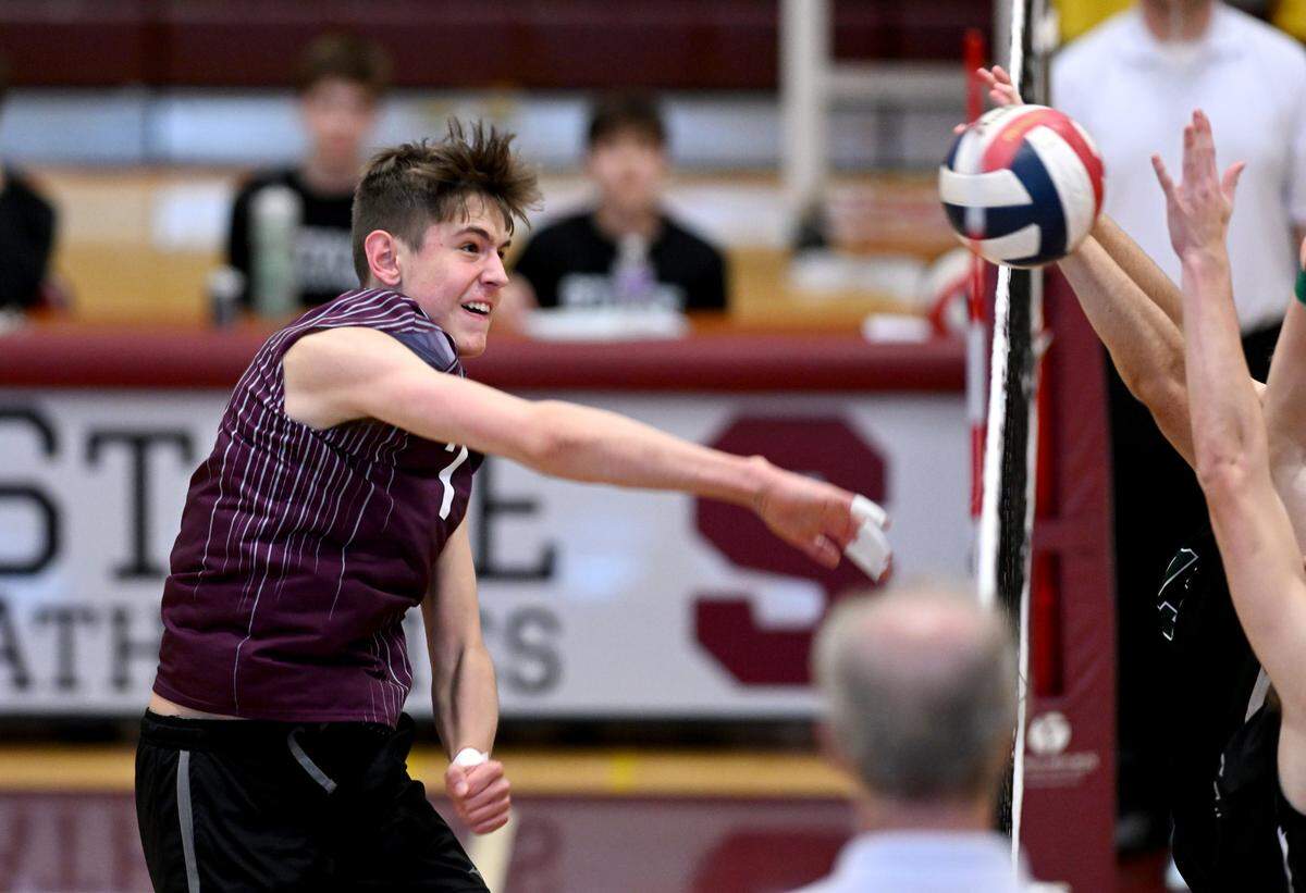 State College’s Carter Weight hits the ball as Central Dauphin defender make the block during the boys volleyball game on Wednesday, May 10, 2023.